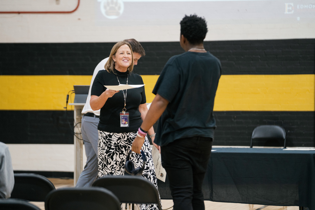 Teacher handing an award to a student