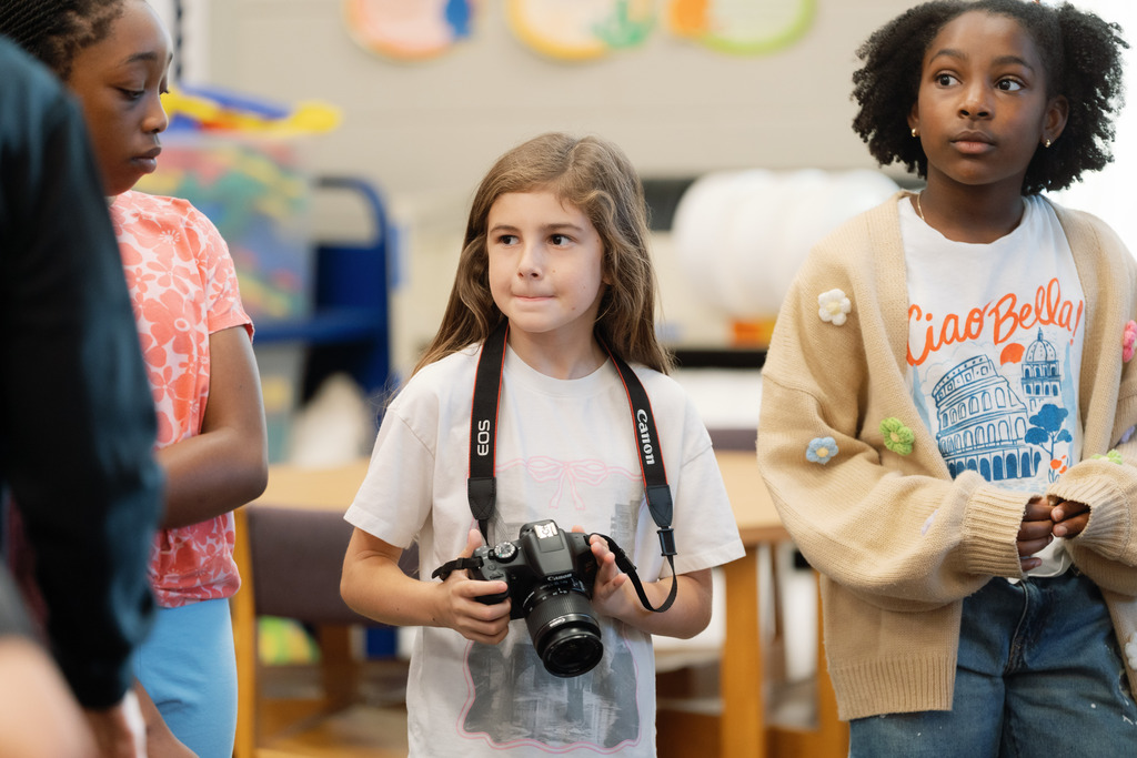 girl holding camera and looking off