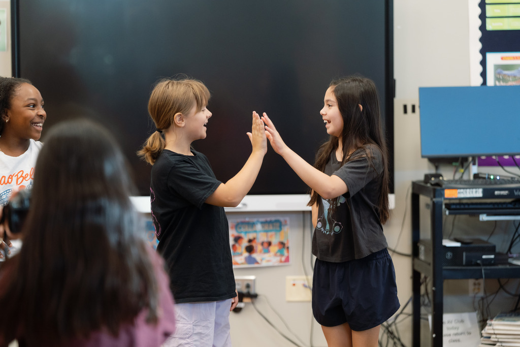 2 girls high fiving