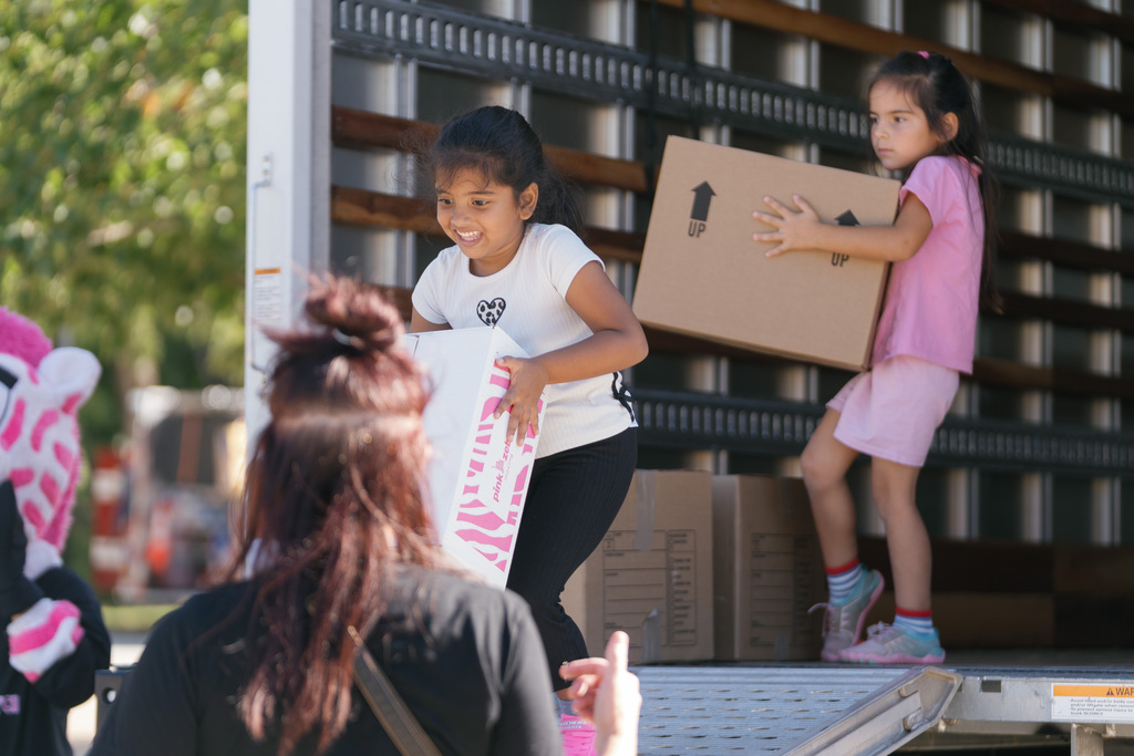 girls carrying boxes