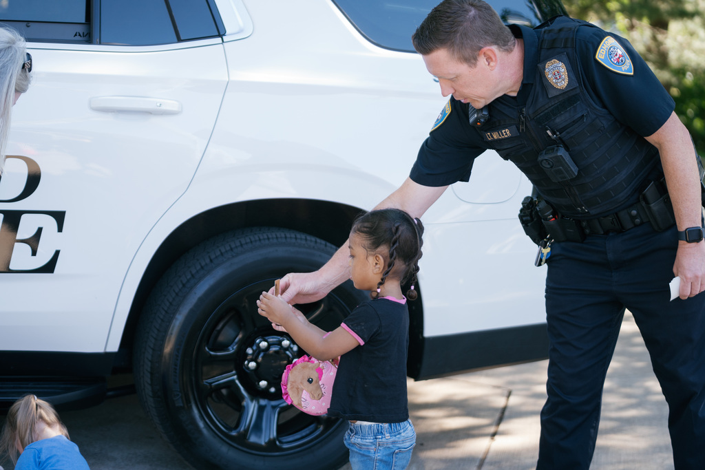 police officer handing a student a badge