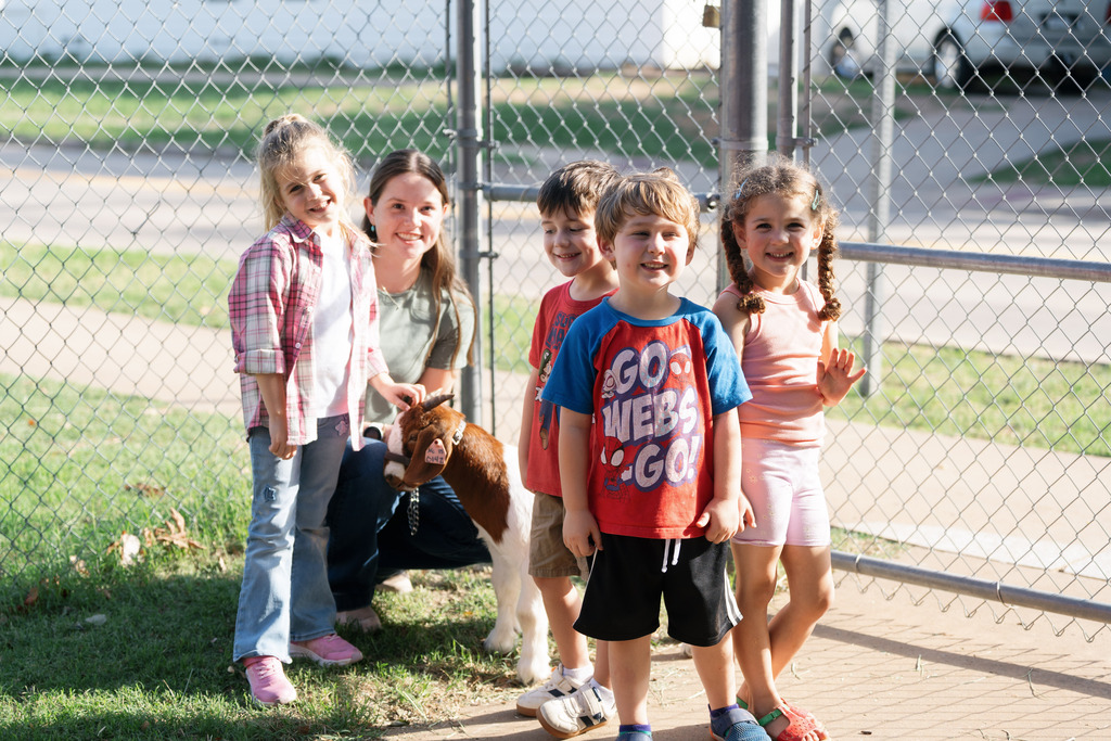 students posing with a goat