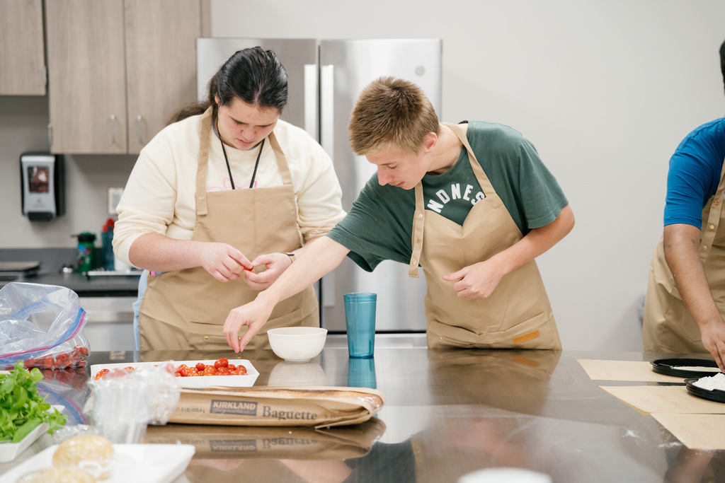 Students preparing tomatoes for pasta