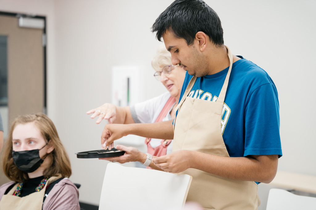 Student holding a plate of baking flour