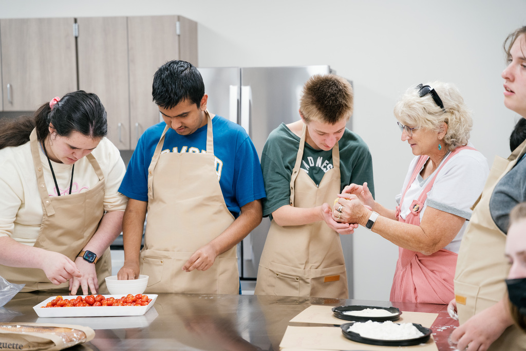Students preparing dough and tomatoes for pasta