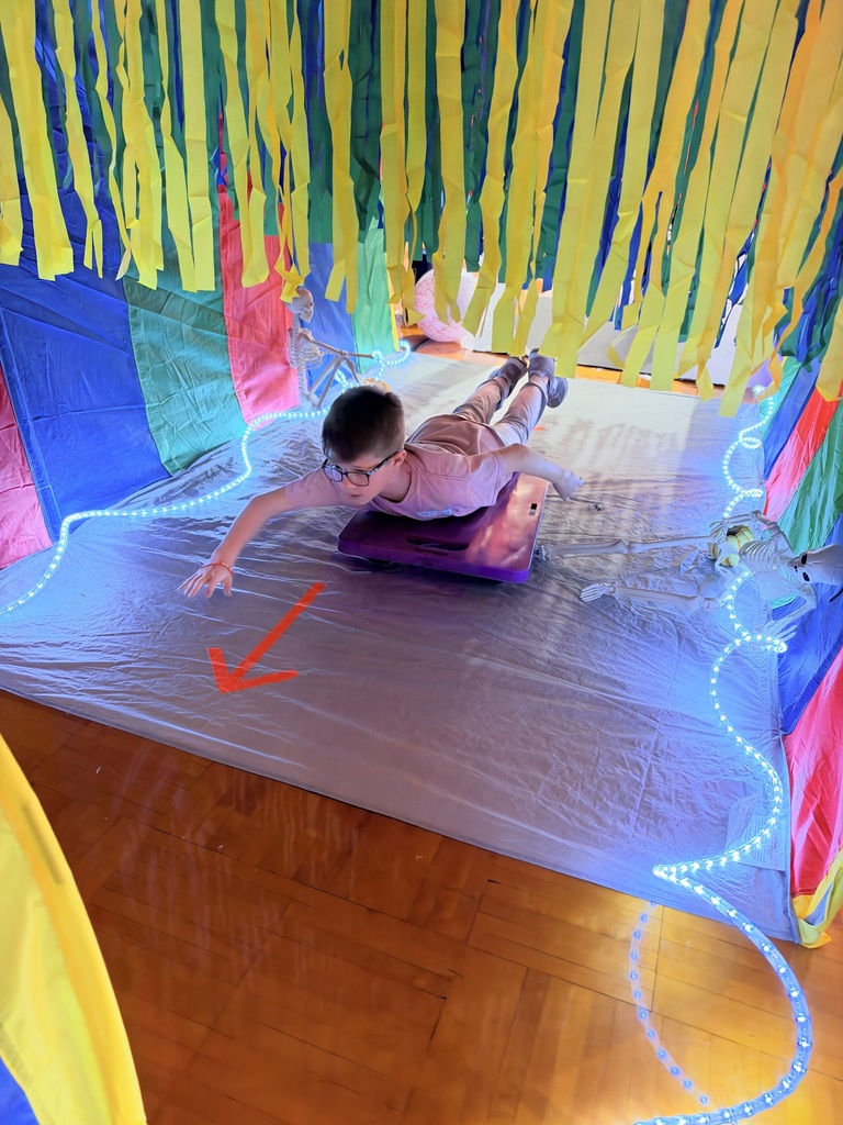 student sliding through a tunnel in pe class