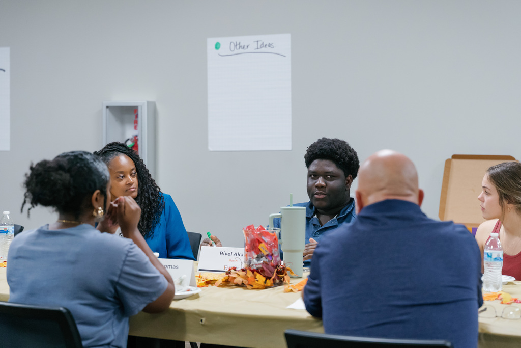 student talking at a table