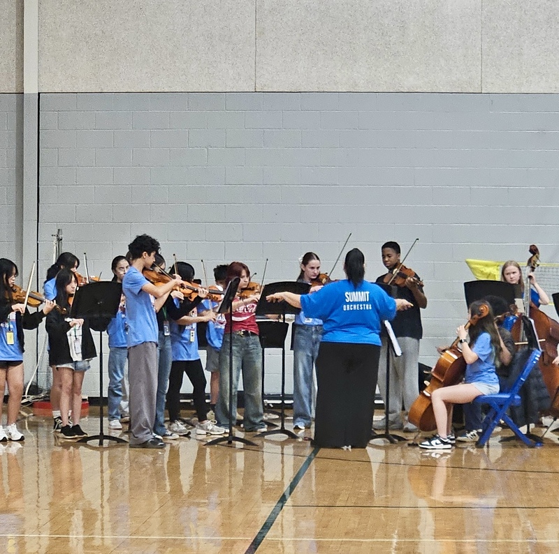 Orchestra performs in the gym for 5th grade visits.