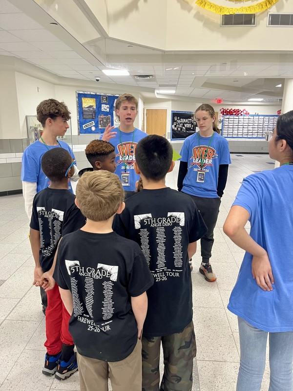 WEB leaders guide a group of middle school students through the commons area of Summit.
