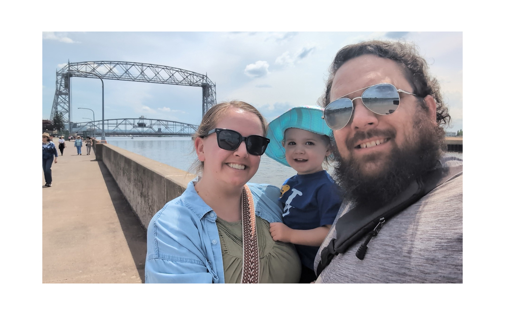 Three people in front of a bridge