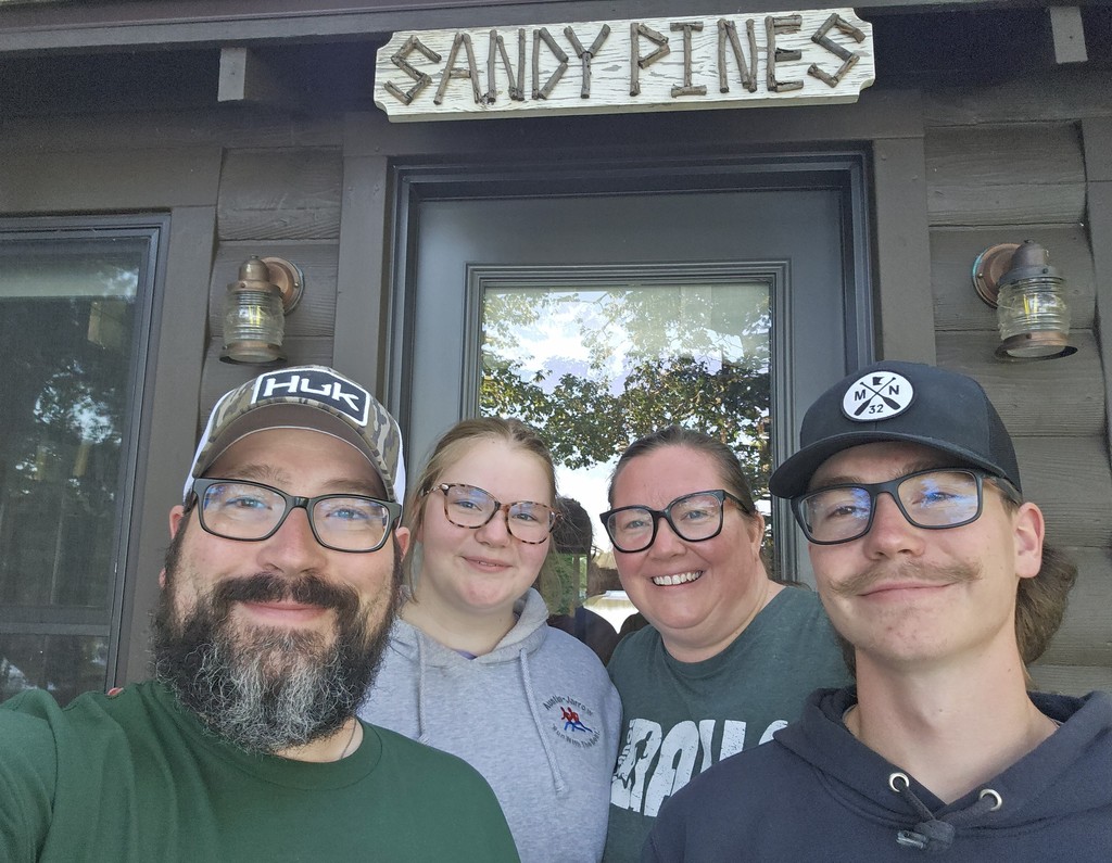 family in front of cabin