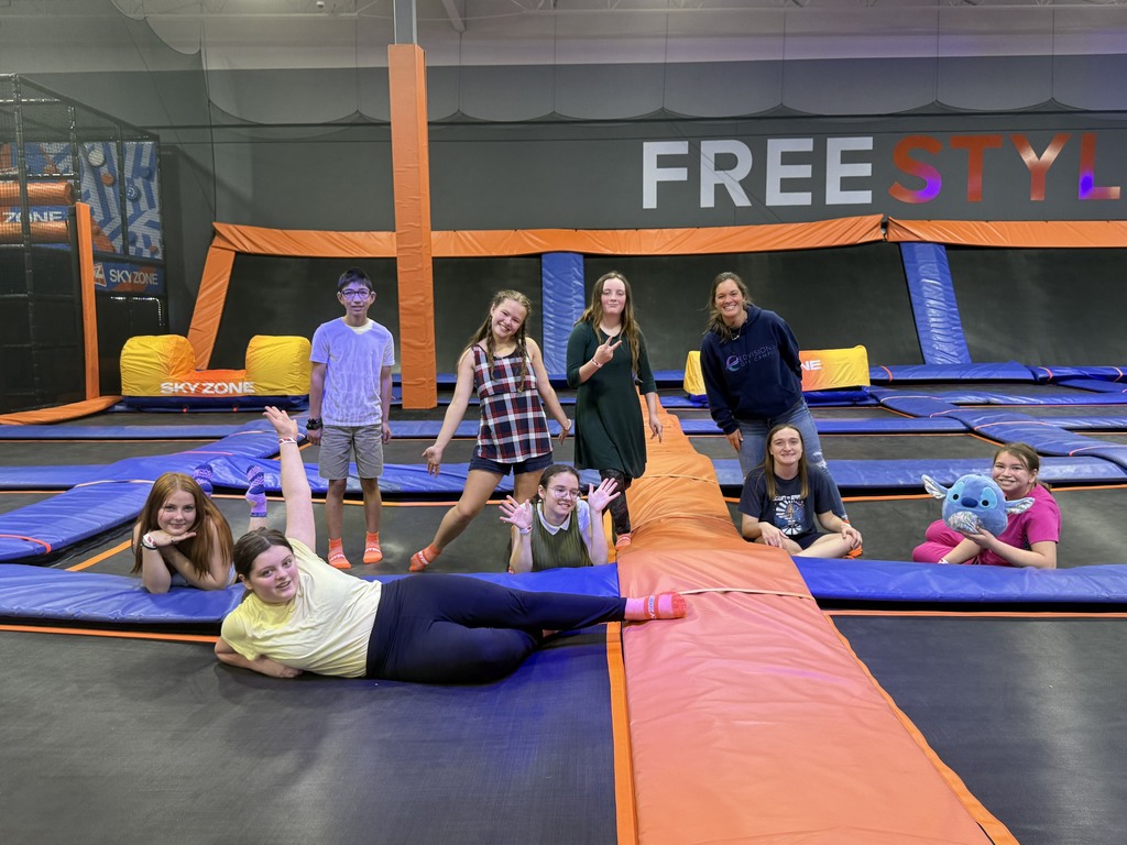 group of students posing on trampolines