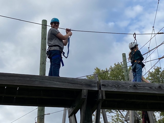 students on a ropes course, high in the air