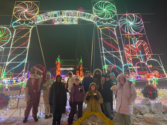 group in front of Bentleyville 2025 sign