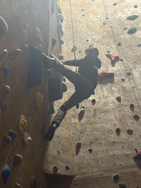 student rock climbing