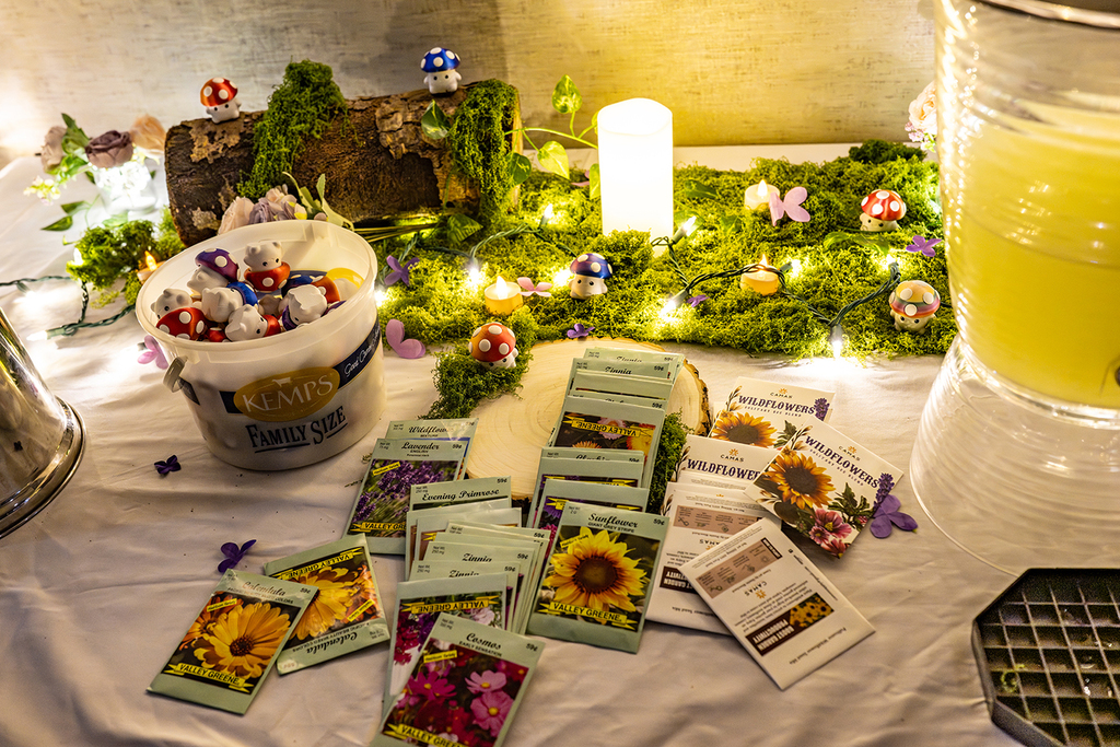 table with tea lights, seed packets, lemonade, fairy lights