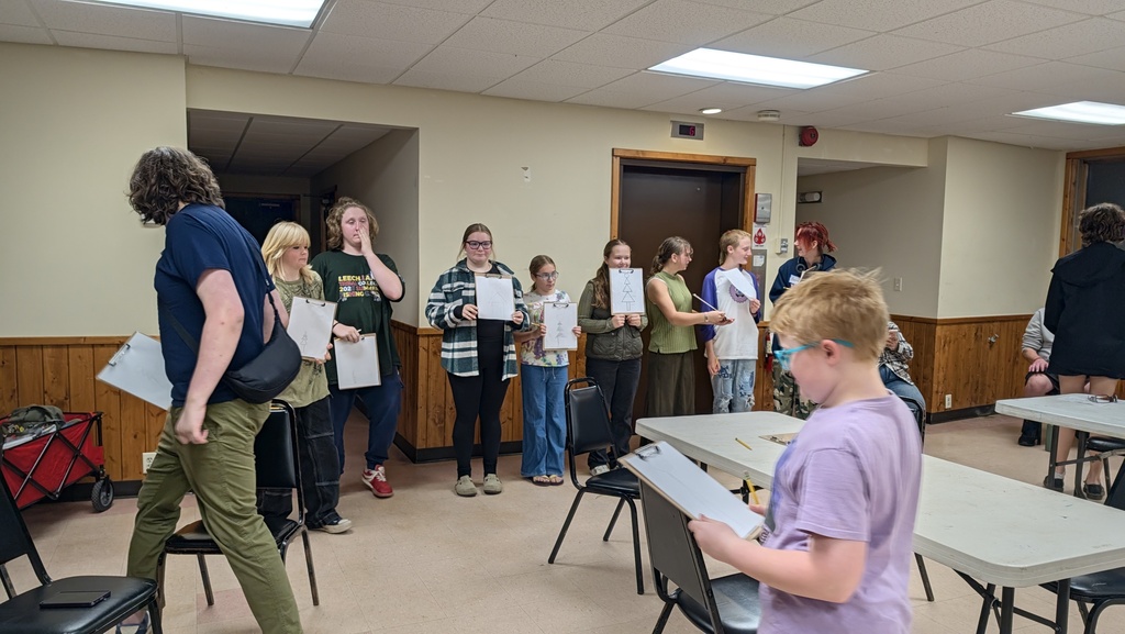 students showing their drawing