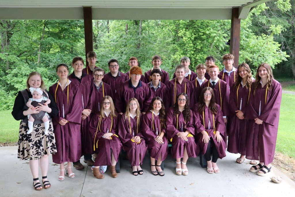 WSGS Class of 2026 in their maroon gowns pictured with Mrs. Sarah Mitchell