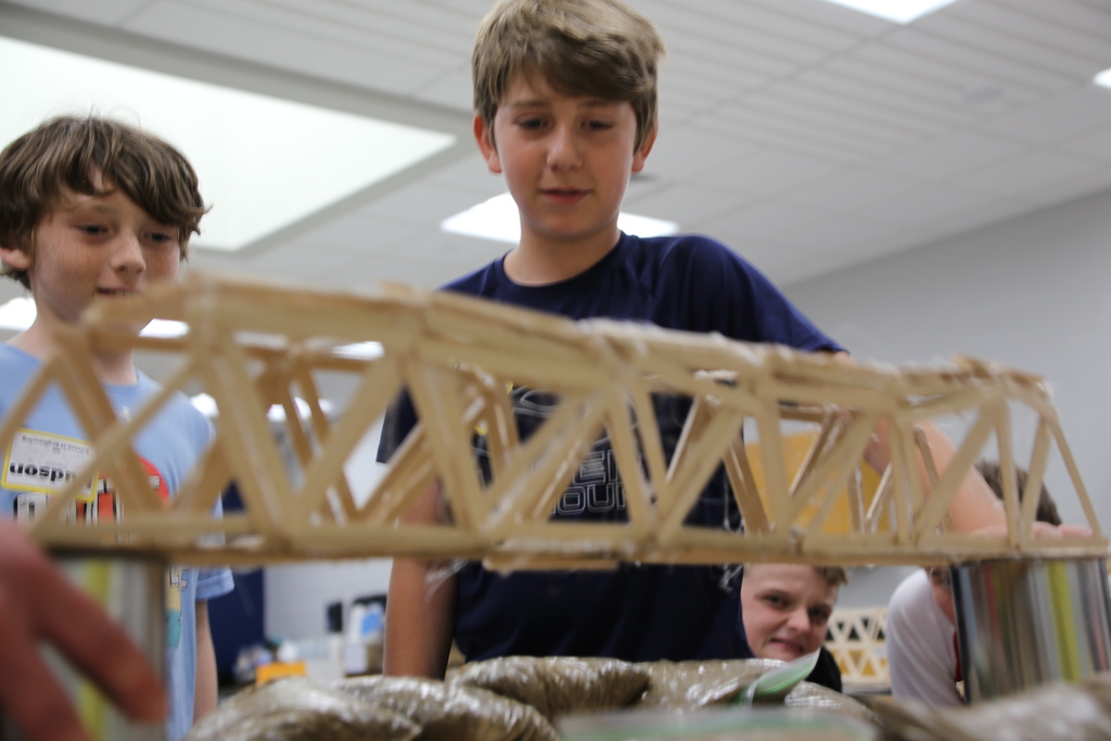 Two boys building a popsicle stick bridge