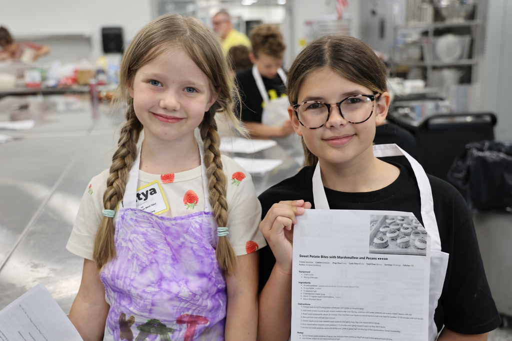 Two girls smiliing with a recipe
