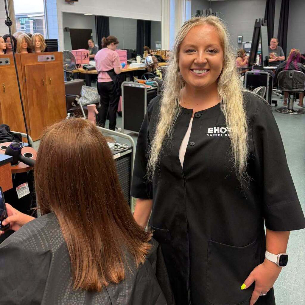 Cosmetology student smiling by client