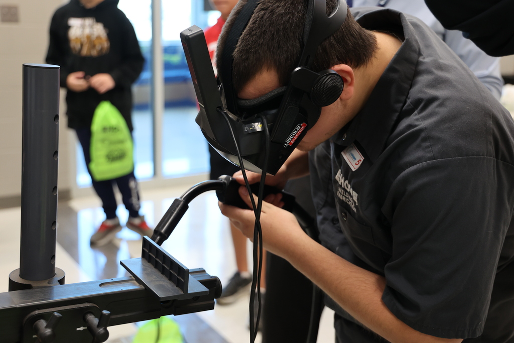 student trying a welding simulator