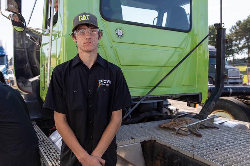 student standing behind semi truck cab