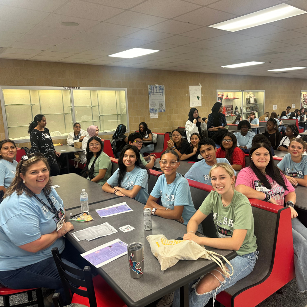 students and teacher at tables talking