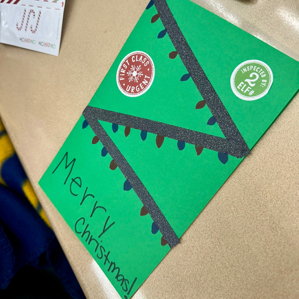 green card with "merry christmas" and a string of lights