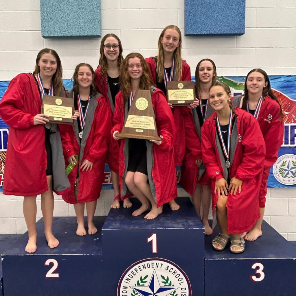 girls swim team on podium with awards