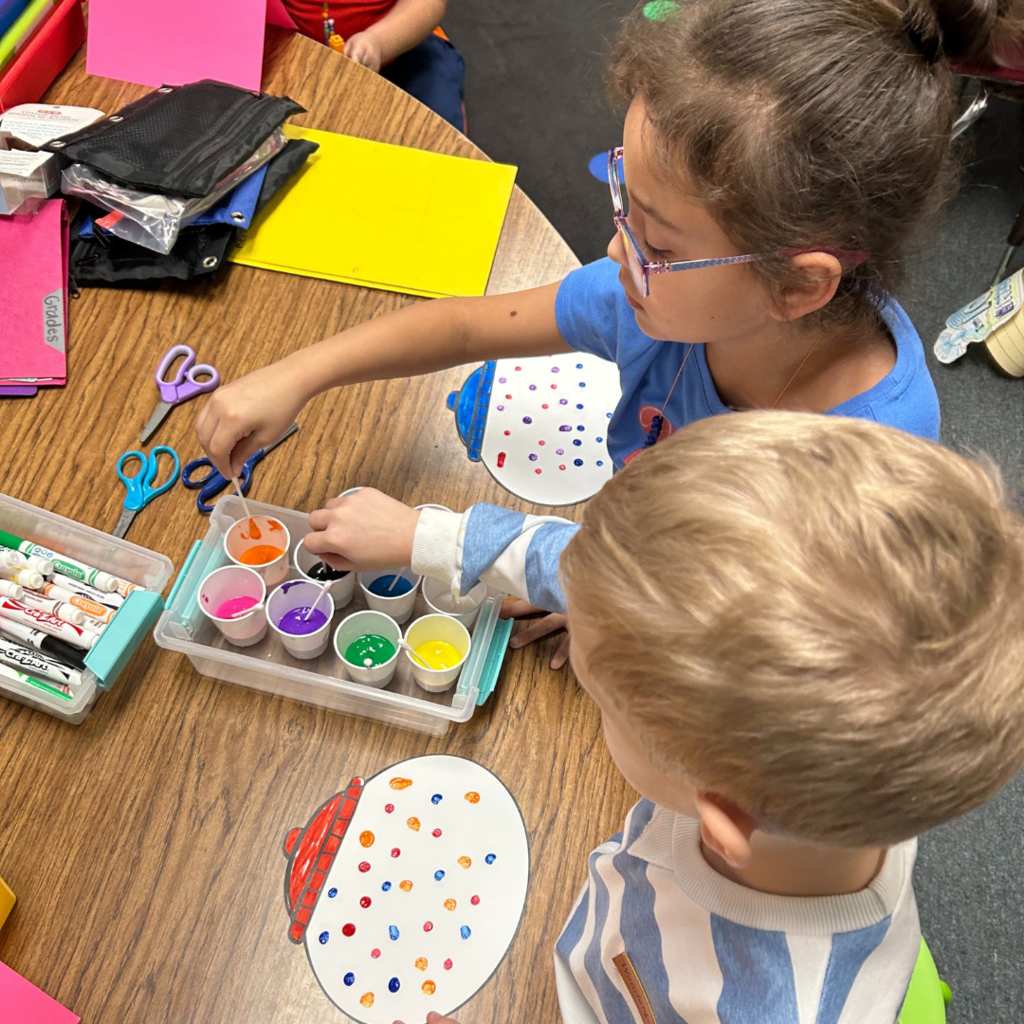 two children are working on crafts at a table