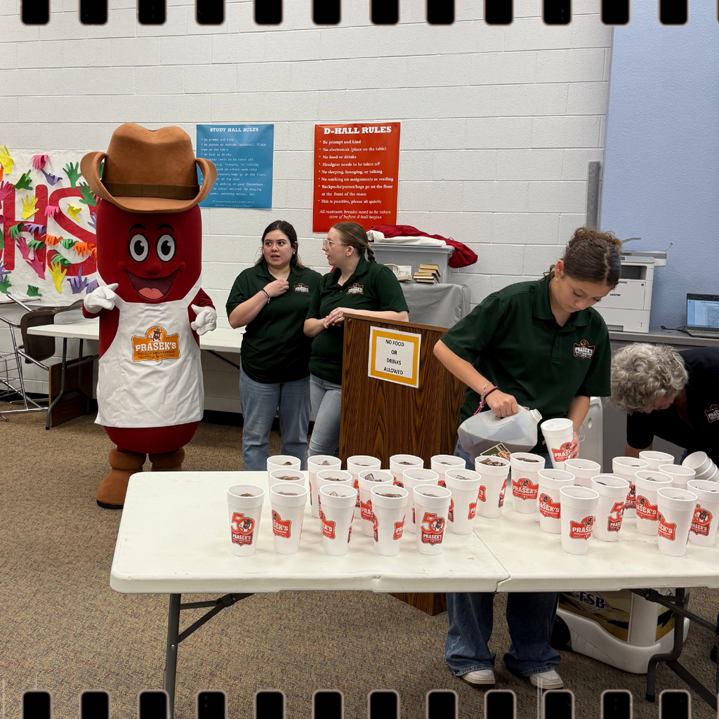 prasek's mascot with people pouring tea