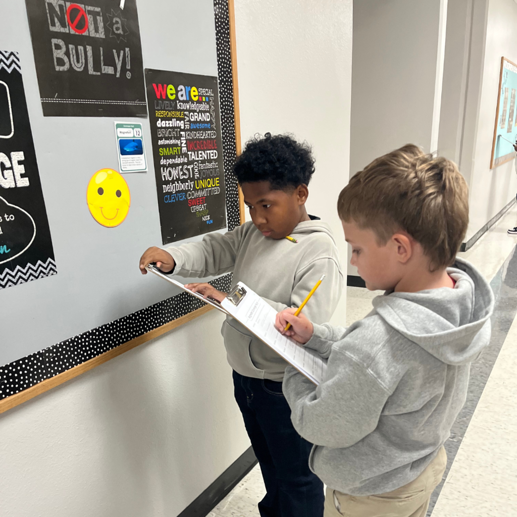 kids with clipboards standing while working