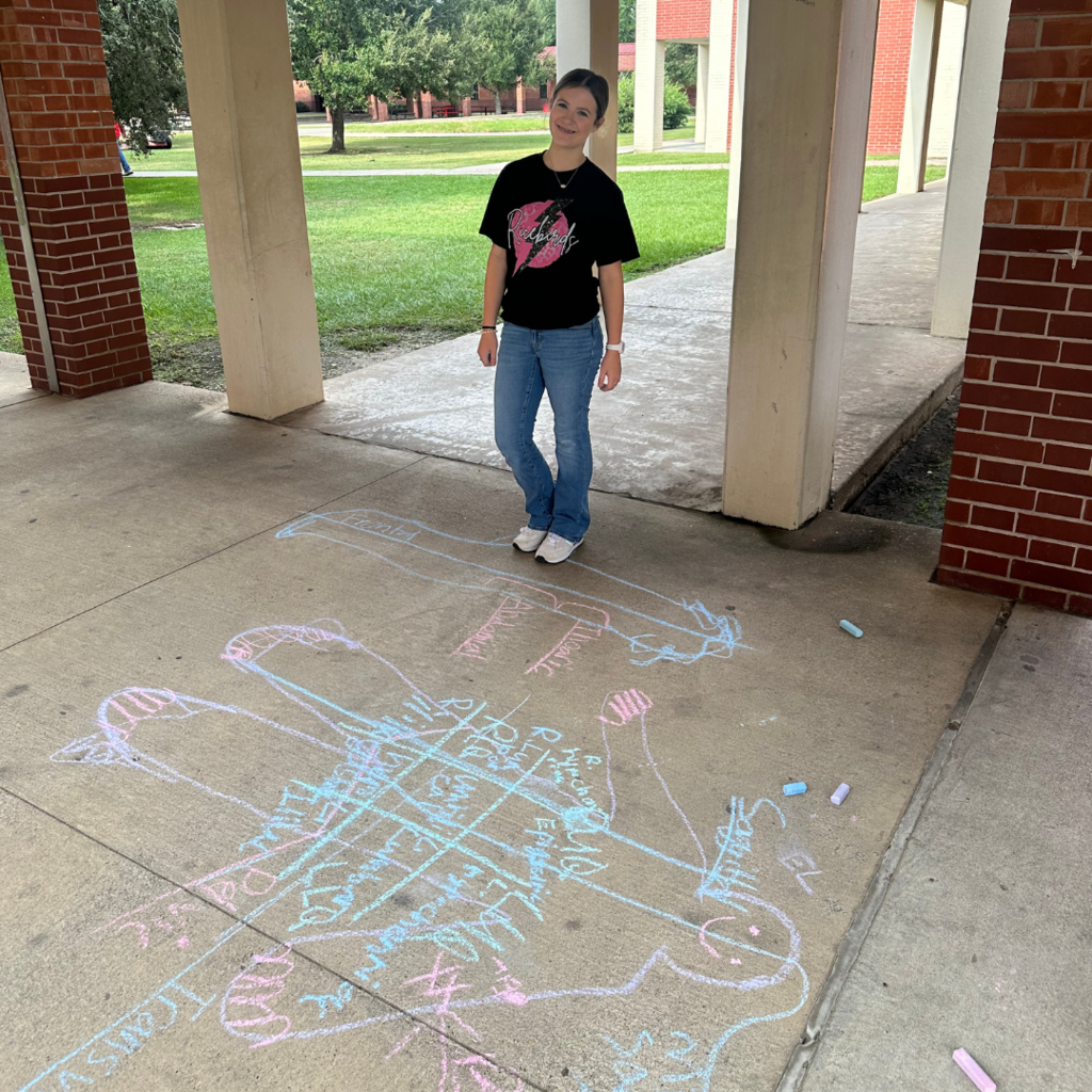 student learning terms with sidewalk chalk and lifesize drawings 
