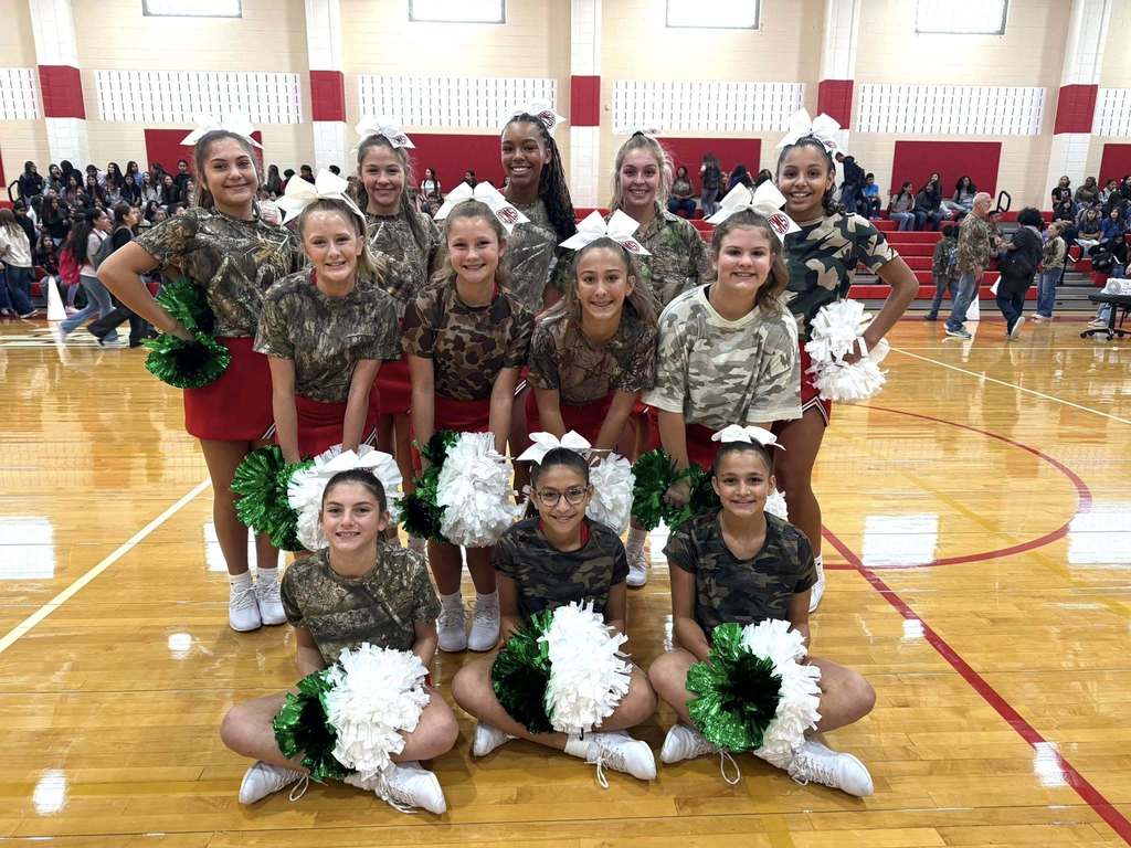 middle school cheer team in camo shirts at pep rally
