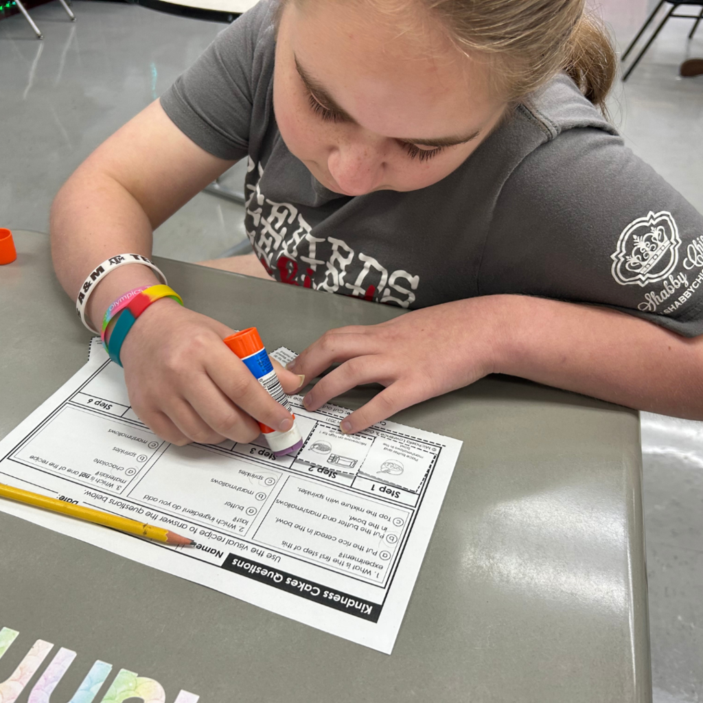 girl working on paper with cut and paste