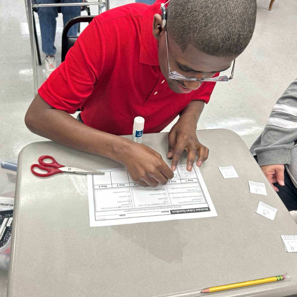 boy working on paper with cut and paste
