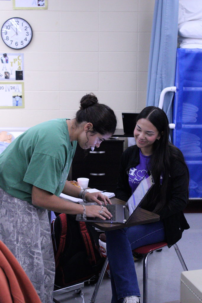 students at meeting working on laptop