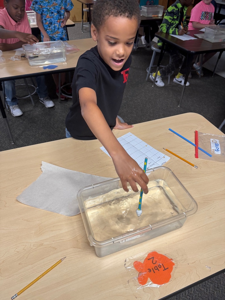 kids observing and taking notes about objects in container of water