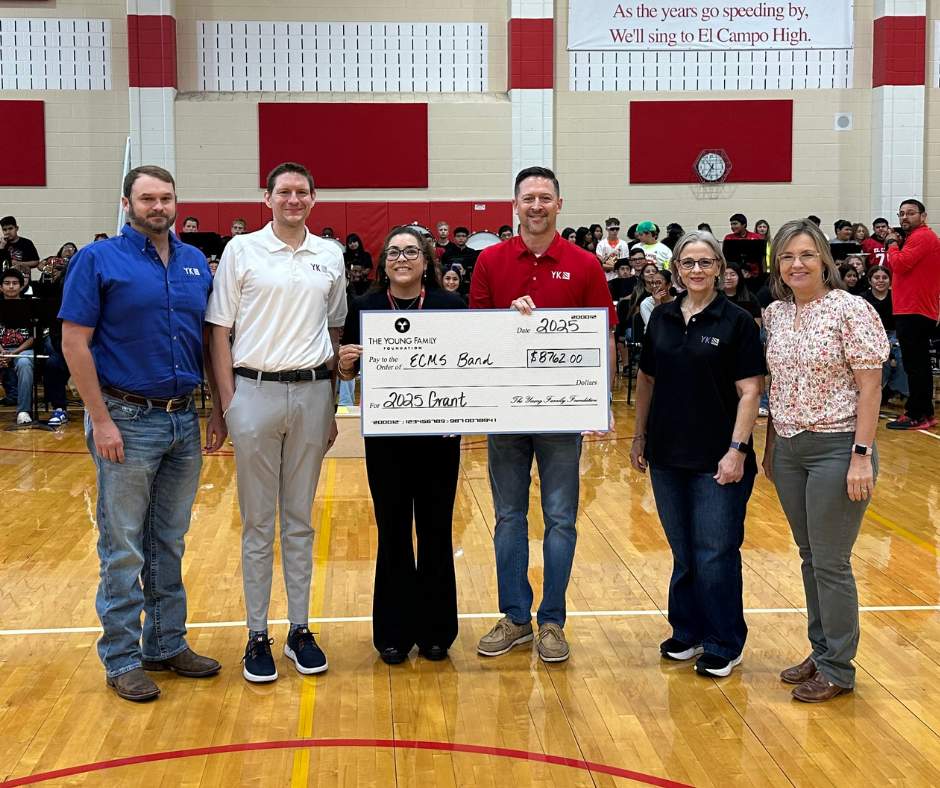 band director and principal with Young family members and a big check