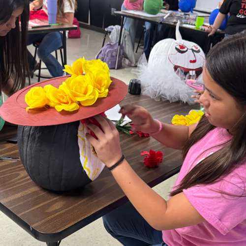 student painting a pumpkin
