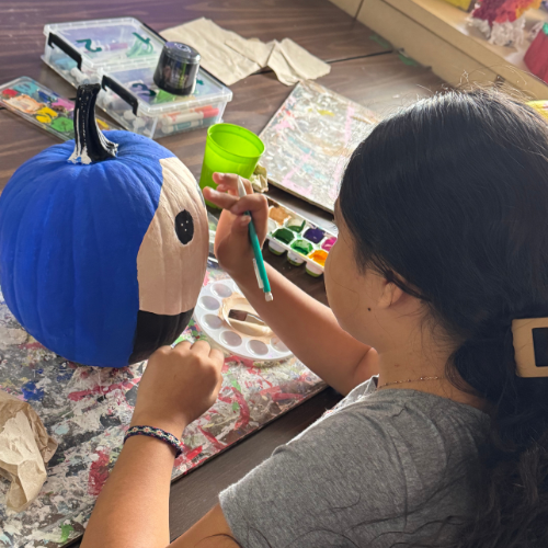 student painting a pumpkin