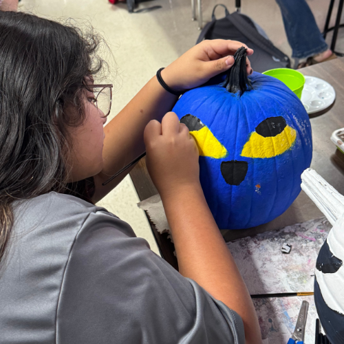 student painting a pumpkin 