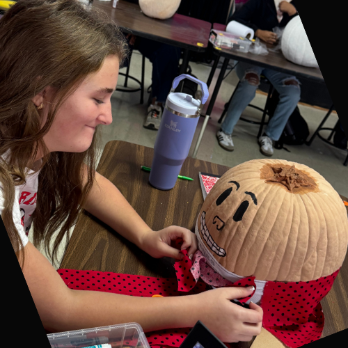 student painting a pumpkin