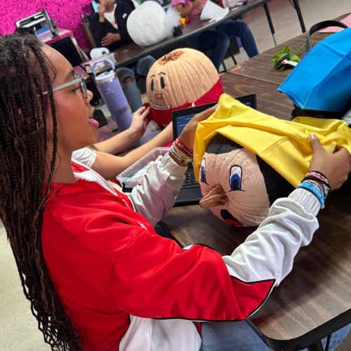student painting a pumpkin