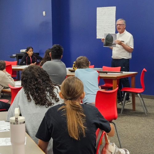 Dimmick showing artifact to students