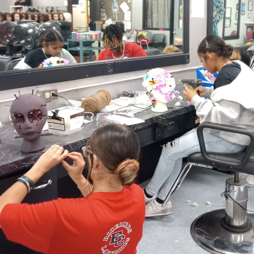 students painting maniquinn faces with nails in the head