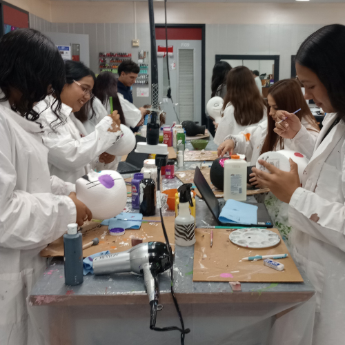 students painting maniquinn faces  at table