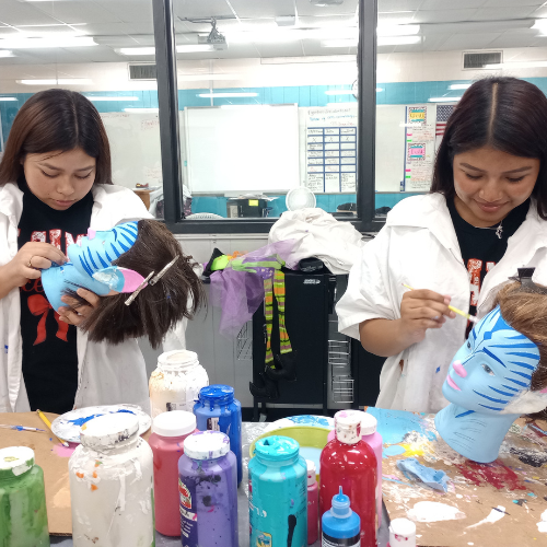 students painting maniquinn faces blue