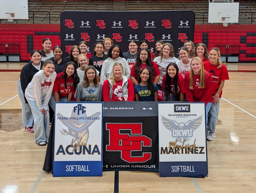 teams surrounding coach and the 2 girls who signed